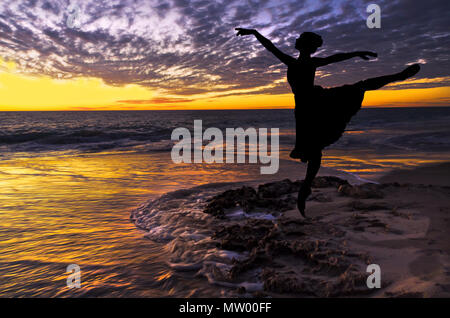 Silhouette di una ballerina in spiaggia al tramonto Foto Stock