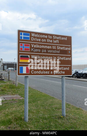 Welcome to Shetland guidare a sinistra segnaletica a Sumburgh aeroporto all'uscita del parcheggio auto in diverse lingue Foto Stock