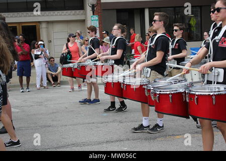 Il Memorial Day Parade high school band drum sezione marciando attraverso il calore. Foto Stock