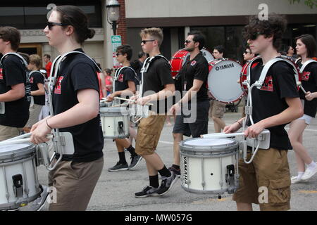 Il Memorial Day Parade high school band drum sezione marciando attraverso il calore. Foto Stock