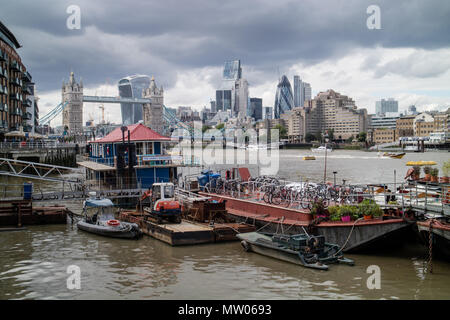 Vista della città di Londra e al Tower bridge da est con barconi, barche e case galleggianti in primo piano. Foto Stock