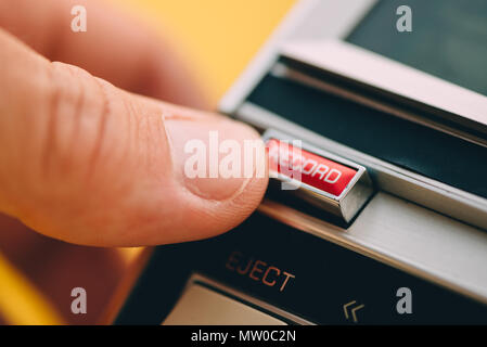 Dito spingendo il pulsante Record su vintage riproduttore di audiocassette, close up retrò con tecnologia di messa a fuoco selettiva Foto Stock