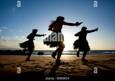 Tre maschi ballerini hula al tramonto di Wailea, Maui, Hawaii. Foto Stock