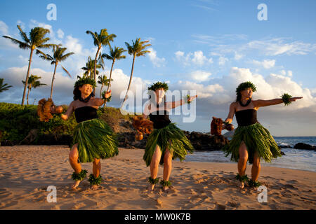 Tre danzatori di hula al tramonto di Wailea, Maui, Hawaii. Foto Stock