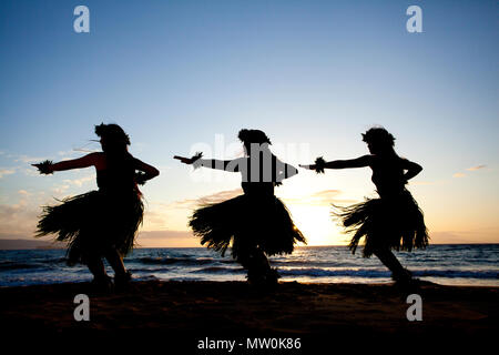 Tre danzatori di hula al tramonto di Wailea, Maui, Hawaii. Foto Stock