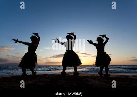 Tre danzatori di hula al tramonto di Wailea, Maui, Hawaii. Foto Stock