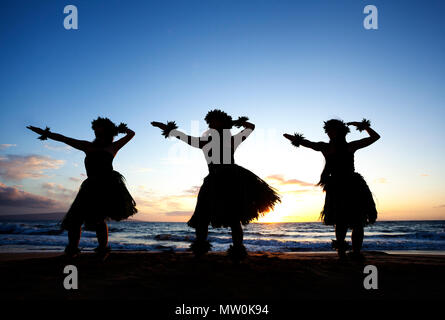 Tre danzatori di hula al tramonto di Wailea, Maui, Hawaii. Foto Stock