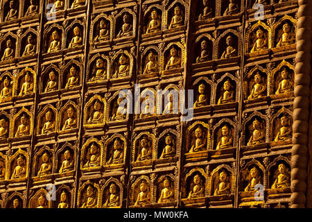 Piccolo Buddha immagini sul lato di un massiccio obelisco in grotte di pietra calcarea di Pindaya, Birmania. Foto Stock