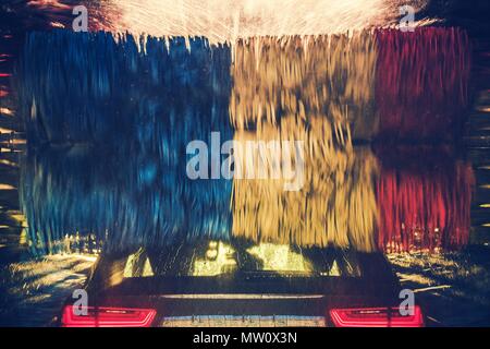 Colorata Car Wash in azione. Veicolo moderno all'interno della filatura delle spazzole di lavaggio. Foto Stock