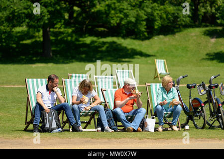 I turisti in rilassanti sedie a sdraio a pranzo dalla serpentina, Hyde Park, London, Regno Unito Foto Stock