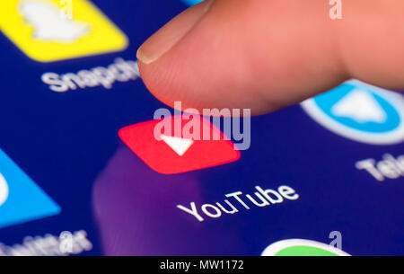 Dito premuto icona di Youtube per caricare le app su un tablet o smartphone touchscreen. Foto Stock