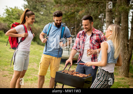 Un gruppo di giovani godendo il barbecue nella natura Foto Stock