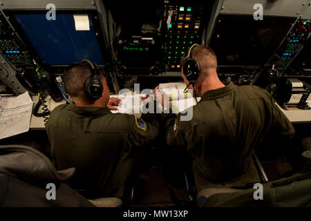 Stati Uniti Air Force Il Mag. Izzy Remo, sinistra, un conduttore di prova-airborne, E DEGLI STATI UNITI Air Force Capt. Greg Carter, a destra di un vice-missile equipaggio combat commander-airborne, sia dai conti nella 625 a operazioni strategiche Squadron, andare oltre il lancio di missili durante le procedure di volo gloria 220 sopra l'Oceano Pacifico, 26 aprile 2017. Gloria Viaggio è operativo un test di lancio che continua una lunga storia di Gamma Western lancia utilizzata per verificare e convalidare e migliorare la capacità della nazione di forza di missili a gittata intercontinentale. Foto Stock