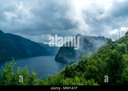 Mistero visualizzare su un fiordo con nebbia e nuvole Foto Stock