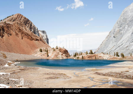 Un piccolo lago di fronte ad una vista panoramica nelle montagne della Sierra Nevada. Foto Stock