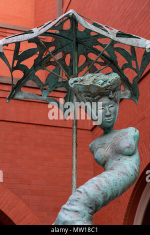 Savannah, Georgia - 10 Aprile 2018: Spagnolo Signora con la sua scultura ombrello di Marianne Lerbs si siede in una fontana al di fuori del palazzo in Forsyth hotel Foto Stock