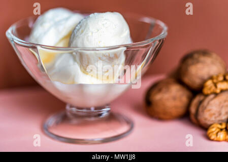 Gelato alla vaniglia nel recipiente e noci Foto Stock