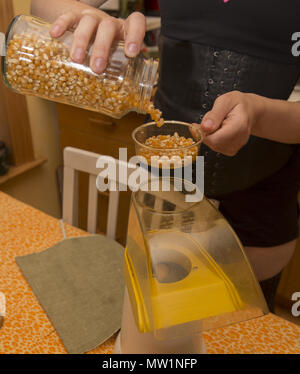 Fare popcorn con un elettrico popper a casa. Foto Stock