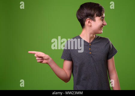 Giovani iraniani bello ragazzo adolescente contro lo sfondo di colore verde Foto Stock