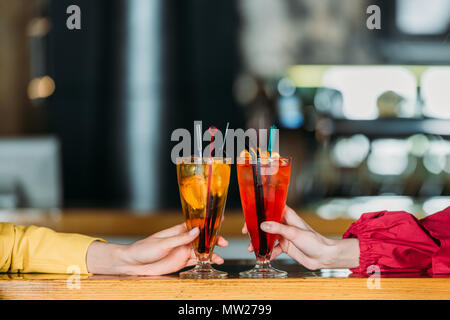 Ritagliato colpo di donne azienda bicchieri di cocktail al bancone bar Foto Stock