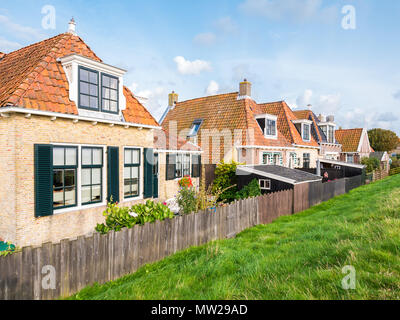 Piccoli cortili della vecchia cottages a fianco di dike nella storica cittadina di Makkum, Friesland, Paesi Bassi Foto Stock