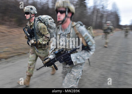 I soldati assegnati a Comanche Company, 1° Battaglione, 501Parachute Reggimento di Fanteria, quarta brigata di fanteria combattere Team (airborne), XXV divisione di fanteria, U.S. Esercito di Alaska, eseguire un 12-Mile piede tattico marzo su base comune Elmendorf-Richardson, Alaska, 27 aprile 2017. Piedi marche sono i movimenti di truppe e di attrezzature, prevalentemente a piedi, con un supporto limitato da parte di veicoli. Essi sono caratterizzati da combat readiness, facilità di controllo, adattabilità al terreno, rallentare la velocità di movimento e maggiore affaticamento del personale. Foto Stock