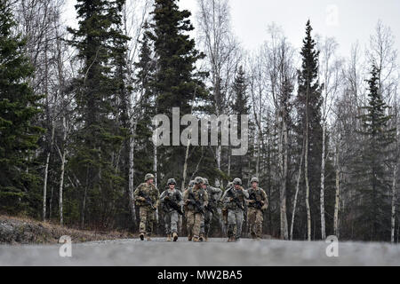 I soldati assegnati a Comanche Company, 1° Battaglione, 501Parachute Reggimento di Fanteria, quarta brigata di fanteria combattere Team (airborne), XXV divisione di fanteria, U.S. Esercito di Alaska, eseguire un 12-Mile piede tattico marzo su base comune Elmendorf-Richardson, Alaska, 27 aprile 2017. Piedi marche sono i movimenti di truppe e di attrezzature, prevalentemente a piedi, con un supporto limitato da parte di veicoli. Essi sono caratterizzati da combat readiness, facilità di controllo, adattabilità al terreno, rallentare la velocità di movimento e maggiore affaticamento del personale. Foto Stock