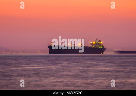 Olio grande petroliera prodotto in mare al tramonto. Logistica aziendale, benzina importazione, esportazione concetto. Sul mare del sud della Cina, Oceano Pacifico. L'immagine orizzontale. Foto Stock