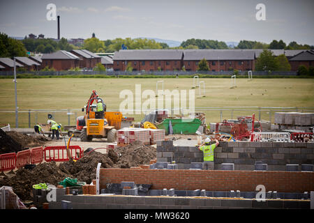 Seddon della costruzione di nuove case per cubo grande luoghi, a Arkwright posto, Melland Road, Gorton, Manchester. apprendista muratore lavorando presso il sito Foto Stock