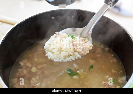 Porridge caldo il riso maiale in pentola Foto Stock