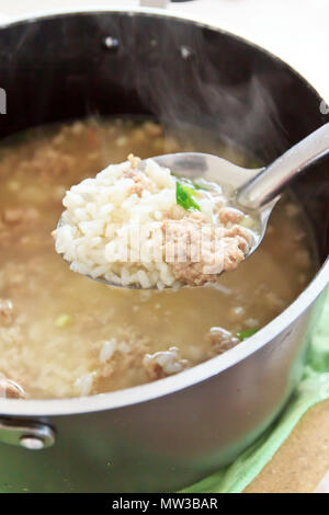 Porridge caldo il riso maiale in pentola Foto Stock