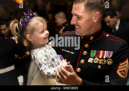 Stati Uniti Marine Corps Staff Sgt. Christopher M. Bess cyber systems chief, sede e società di servizio, 1° Battaglione, 1° Reggimento Marini, 1° Divisione Marine, e sua figlia di due anni Bess Quinlynn, danza durante l'undicesima edizione del padre-figlia danza sul Camp Pendleton, California, Aprile. 28, 2017. Il padre-figlia di danza è un evento annuale tenuto per Active Duty, Riserva e il veterano padri di legame e divertirsi con le loro figlie. Foto Stock