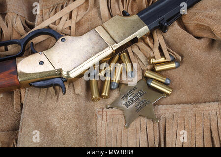 Wild West periodo il fucile a ripetizione con munizioni e sheriff badge Foto Stock