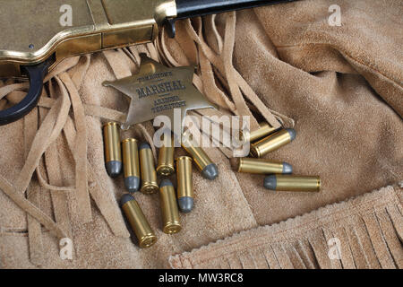 Wild West periodo il fucile a ripetizione con munizioni e sheriff badge Foto Stock