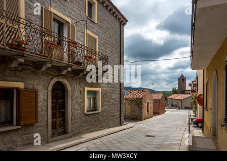 Una pittoresca strada di Sant'Antonio di Gallura con vista del campanile della chiesa, Sardegna Foto Stock