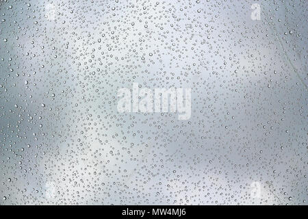 Vista astratta di goccioline di acqua sulla superficie di vetro in un giorno di pioggia Foto Stock