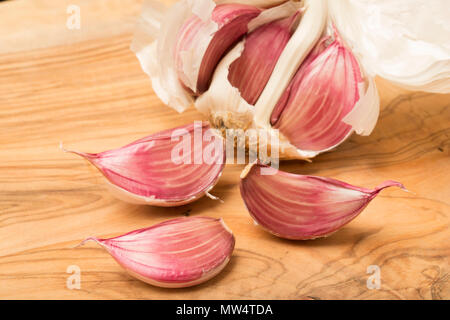 Bulbo aglio e chiodi di garofano acquistato da un supermercato in Inghilterra UK GB su un legno di ulivo tagliere Foto Stock