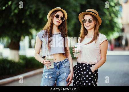 Felice brightful momenti positivi di due ragazze eleganti costeggiata sulla strada in città. Closeup ritratto divertente gioiosa attarctive giovani donne divertendosi, SMIL Foto Stock