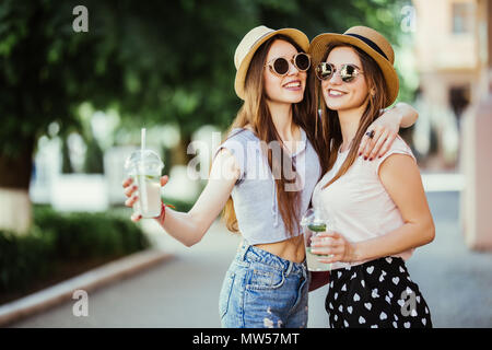 Felice brightful momenti positivi di due ragazze eleganti costeggiata sulla strada in città. Closeup ritratto divertente gioiosa attarctive giovani donne divertendosi, SMIL Foto Stock