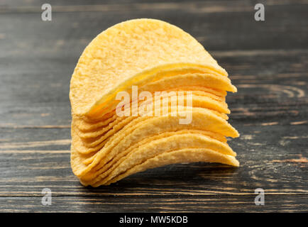 Pila di potato chips su sfondo di legno closeup Foto Stock