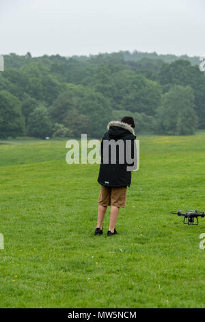 Biracial boy vola drone a Weald Country Park modello di rilascio trattenuto Foto Stock