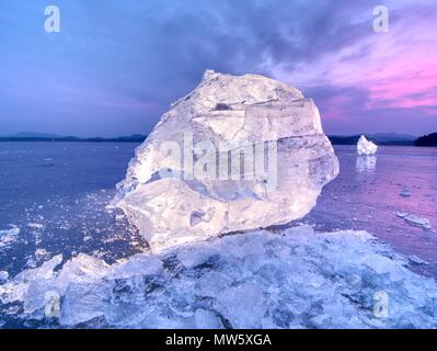 Vista in dettaglio in un ghiaccio con graffi profondi e crepe. Tagliare floe contro al cielo di sera e la luce spot. Foto Stock