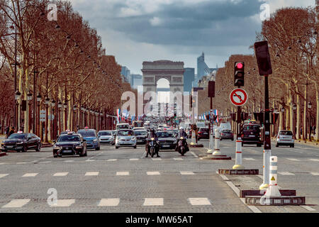 Attesa del traffico in corrispondenza di un segnale vicino a Place de la Concorde sulla Champs-Élysées con l'Arc de Triomphe in distanza , paris , France Foto Stock