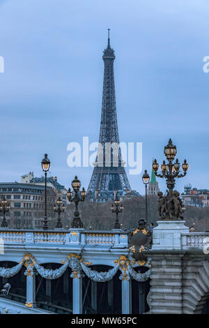 Lampade illuminate al crepuscolo sul ponte Pont Alexandre III con la Torre Eiffel in lontananza, Parigi, Francia Foto Stock