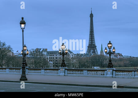 Lampade illuminate al crepuscolo sul ponte Pont Alexandre III con la Torre Eiffel in lontananza, Parigi, Francia Foto Stock