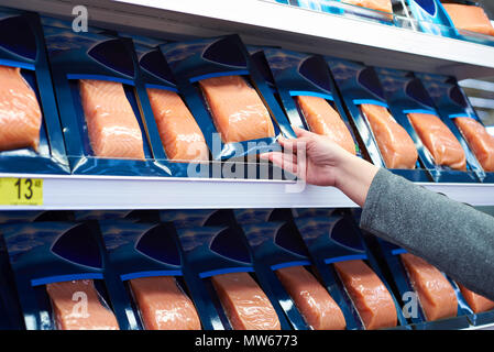 Pesce salmone in mano del compratore presso il negozio di alimentari Foto Stock