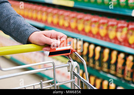 La carta di credito in mano agli acquirenti in negozio Foto Stock