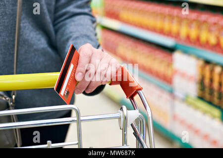 La carta di credito in mano agli acquirenti in negozio Foto Stock