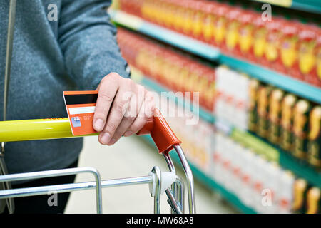 La carta di credito in mano agli acquirenti in negozio Foto Stock