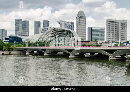 Una barca di crociera noto come twakows corsa attraverso il famoso fiume Singapore. L'edificio sul retro è il famigerato teatro sulla baia, Esplanade. Foto Stock